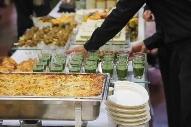 Professional catering services buffet setup with hot dishes, snacks, and beverages