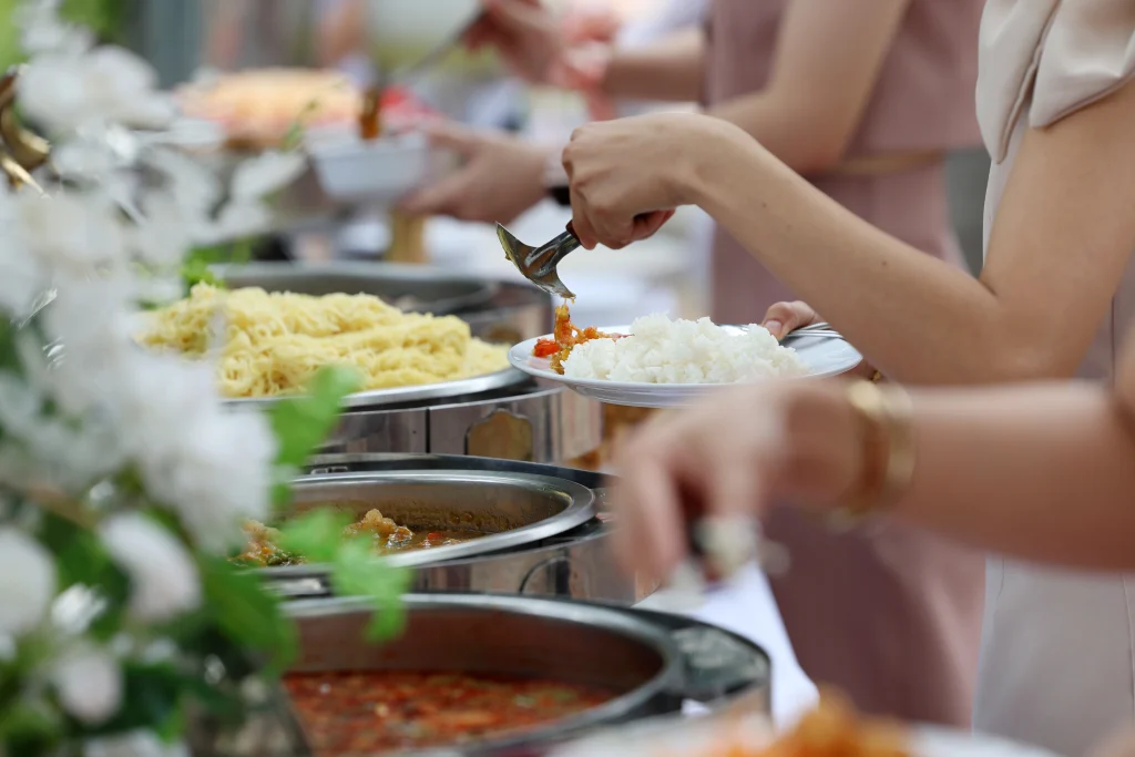 Wedding guests being served fresh white rice and Pan-Asian noodles by vegetarian catering services