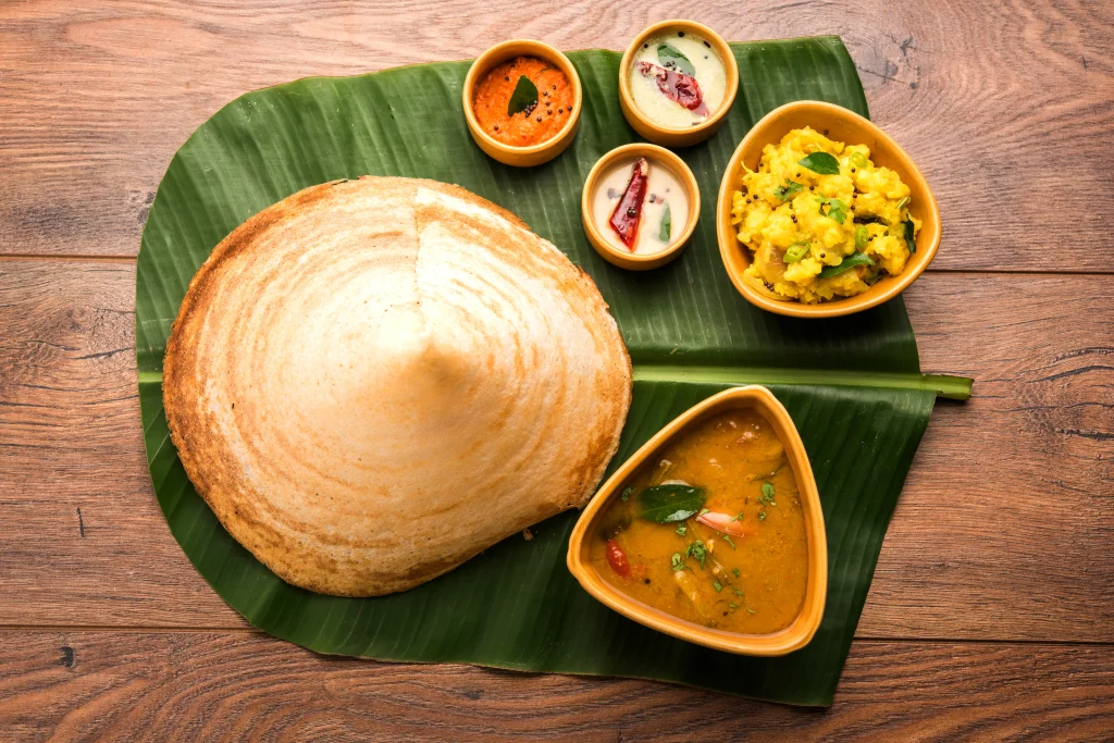 Masala dosa served on banana leaf with sambar, coconut chutney, and potato masala is best South Indian dishes