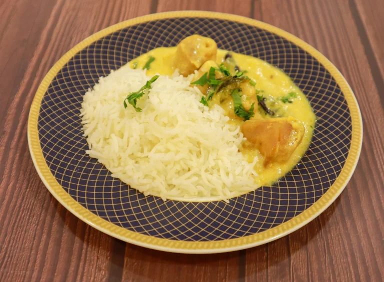 Sarvsri Brahmin Catering Services featuring a serving of steamed basmati rice paired with a creamy, yellow Mor Kuzhambu