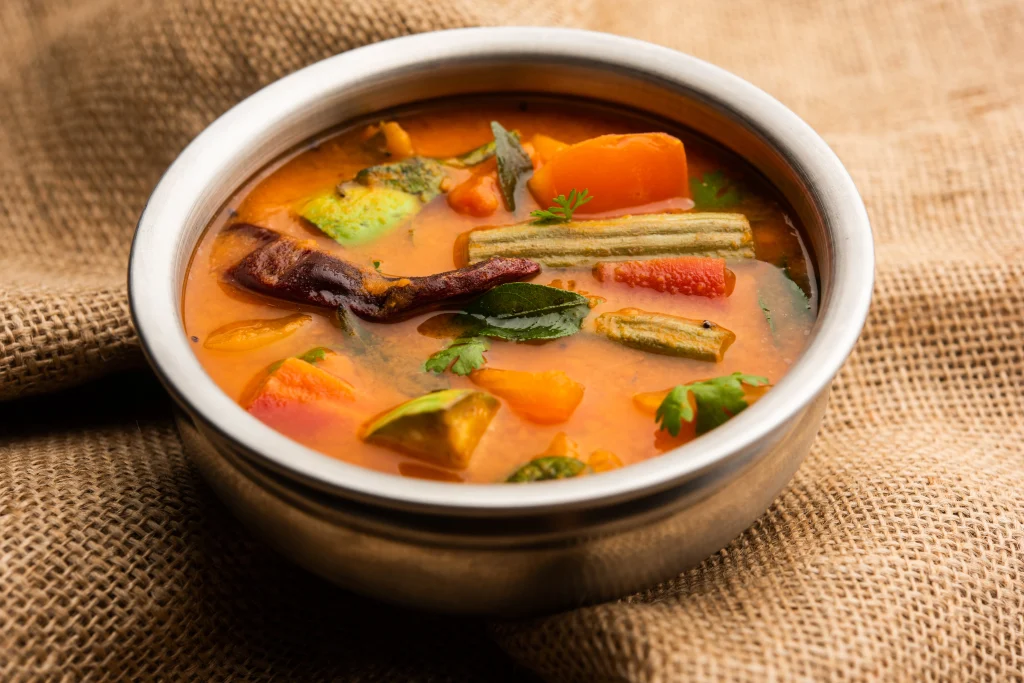classic vegetarian recipes sambar with mixed vegetables like drumstick, carrot, and tomato