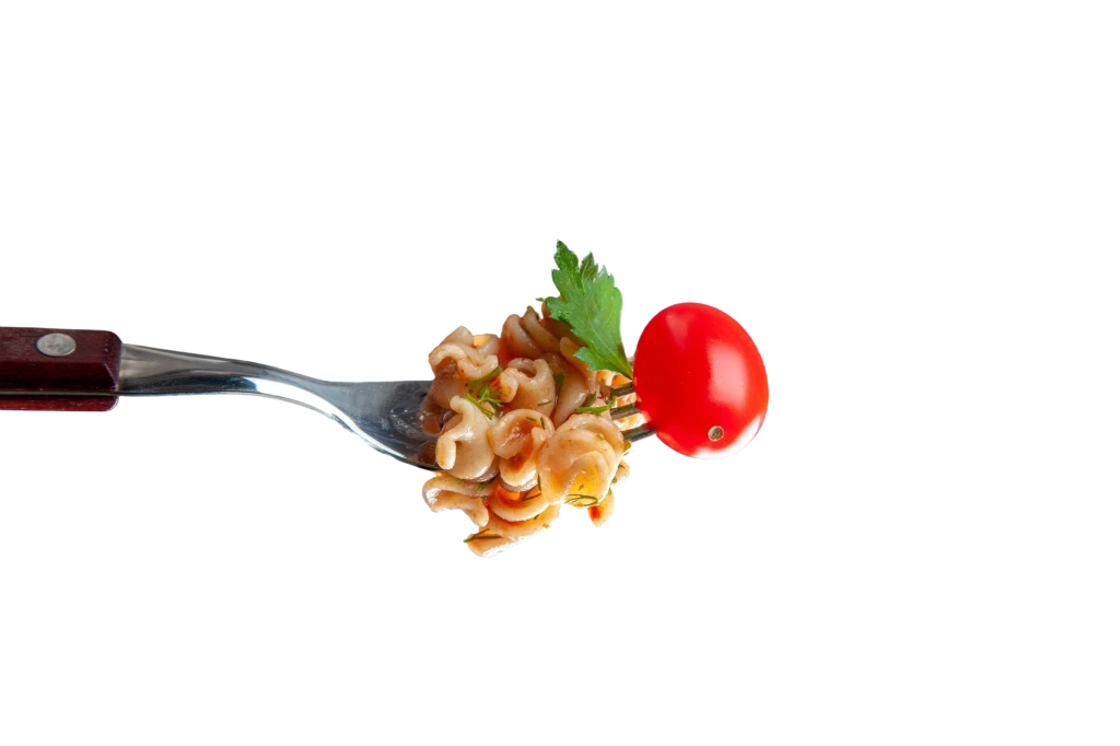 Freshly prepared pure veg fusilli pasta with cherry tomato on a fork, a gourmet holiday appetizer by Sarvsri catering in Chennai