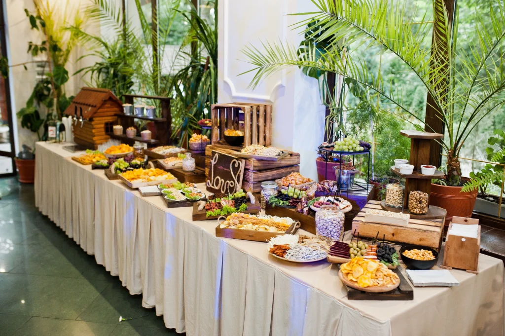 Rustic wedding catering buffet table with snacks, fruits, and appetizers arranged for a reception