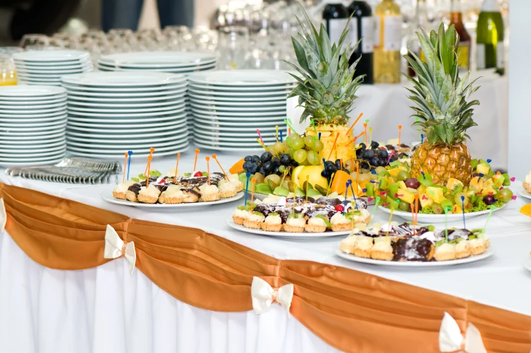Sar V Sri Wedding catering services display with desserts, fresh fruits, and serving plates arranged on a decorated buffet table