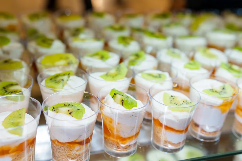 Individual dessert cups with kiwi topping served as part of wedding catering by Sar V Sri