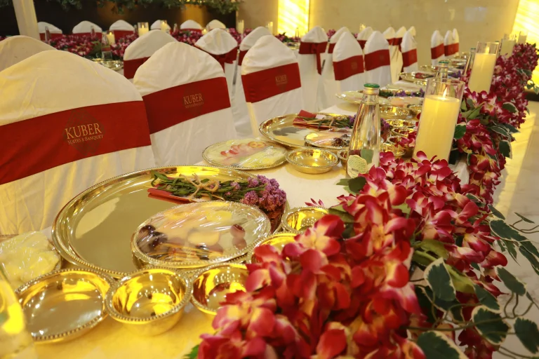 Sophisticated reception dining table setup with floral decor and gold-plated tableware for a premium event by Sar V Sri