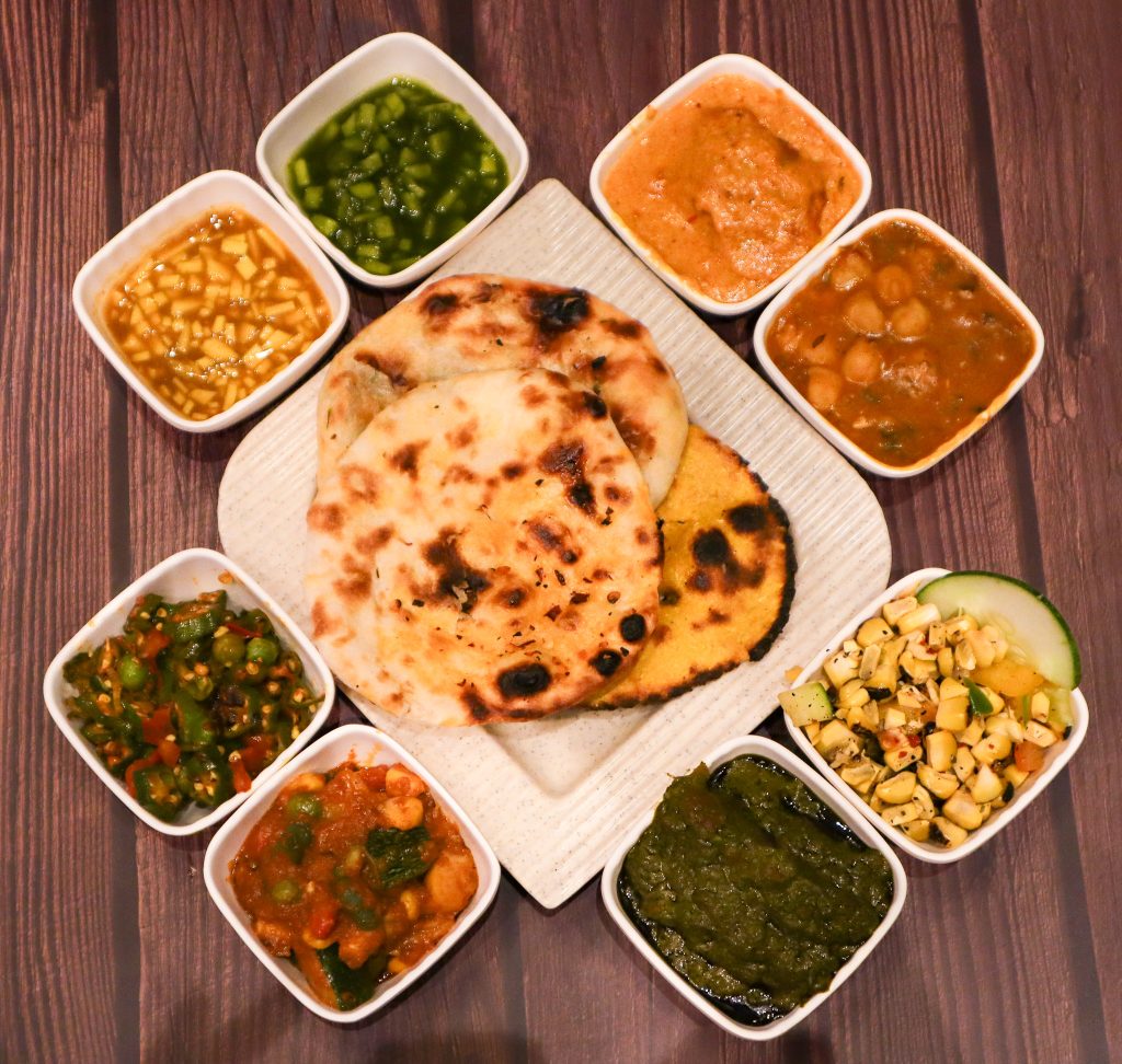 Wedding catering services featuring a variety of naan and curry dishes served with traditional sides by Sar V Sri