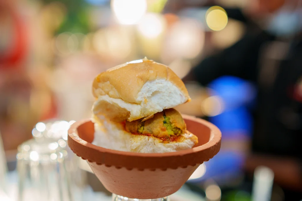 A delicious Maharashtrian vada pav served in a traditional clay bowl, showcasing the iconic street food