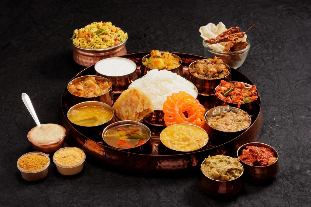 Authentic South Indian platter with rice, lentils, vegetable curries, and accompaniments served in copper bowls