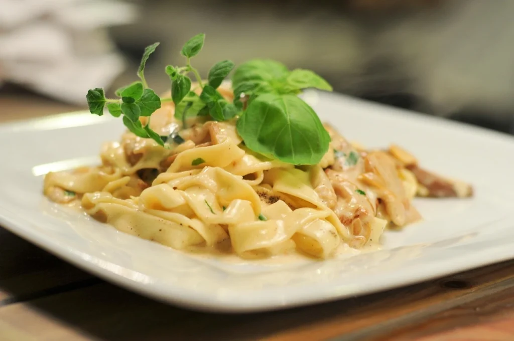 Italian creamy fettuccine pasta garnished with fresh basil