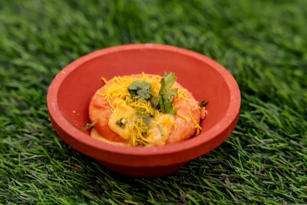 Street food dahi vada served in a clay bowl with chutneys and sev