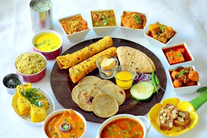 Traditional Gujarati thali with a variety of vegetarian dishes, rotis, dal, rice, and sweets served by Sar V Sri Gujarati Catering Services