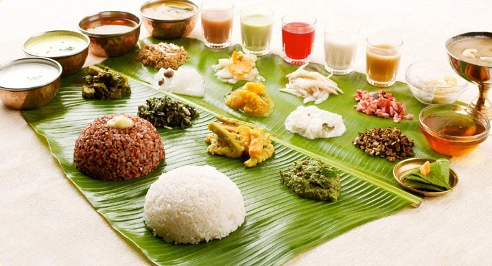Traditional Tamil Nadu meal with rice, curries, pickles, and beverages served on a banana leaf