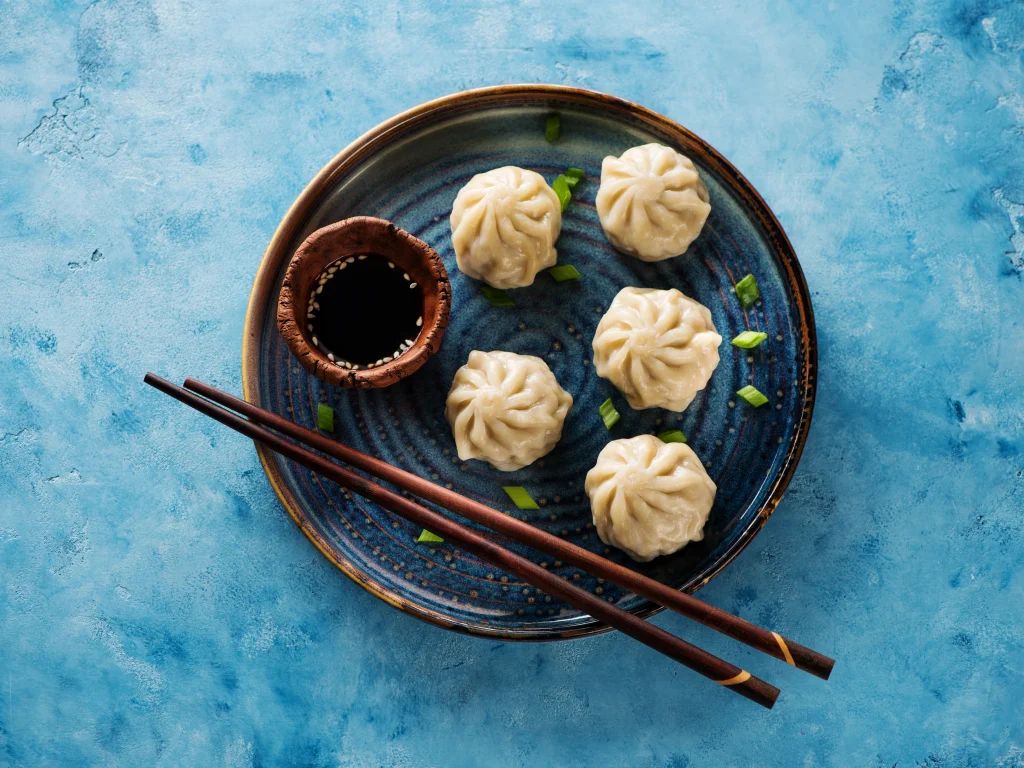 A gourmet Pan Asian catering services platter by Sarv Sri featuring five intricately pleated steamed vegetable dumplings