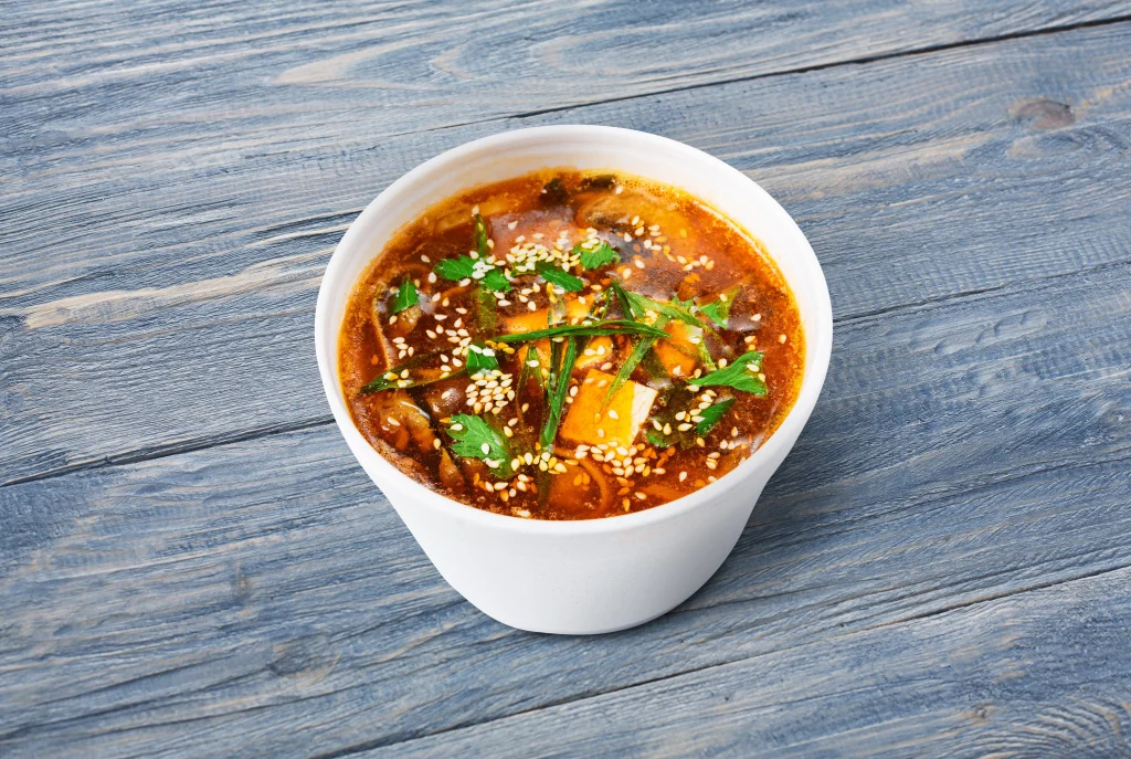 A white bowl of authentic Thai-style Tom Yum tofu soup