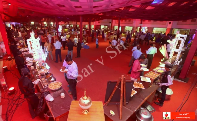 Corporate event with vibrant food counters and guests enjoying a lively dining experience by Sar V Sri